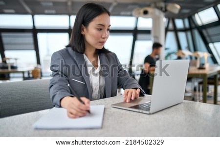 Young Asian business woman office employee using laptop watching webinar. Female professional worker, company manager working on computer online doing corporate data digital technology analysis. Royalty-Free Stock Photo #2184502329