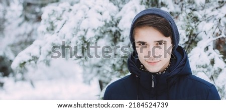 Young man in winter clothes walking, Portrait of a Happy guy photo banner with copy space. Leisure, sport and people concept