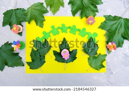 Child playing with plasticine and  paper and natural leaves. Protection of environment, Save our planet. Ecology concept. Concept of art learning and education 