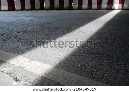 Light Beam on the Road with Red and White Barrier.