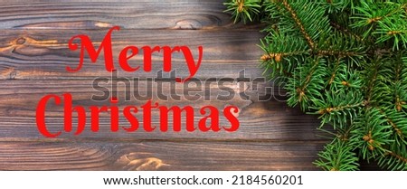 Merry Christmas text. Christmas gray wooden background with fir tree and copy space. top view banner empty space for your design.