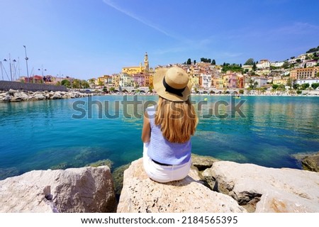 Vacation relax. Girl sitting on stone enjoying landscape of French Riviera on sunny day, Menton, France. Royalty-Free Stock Photo #2184565395