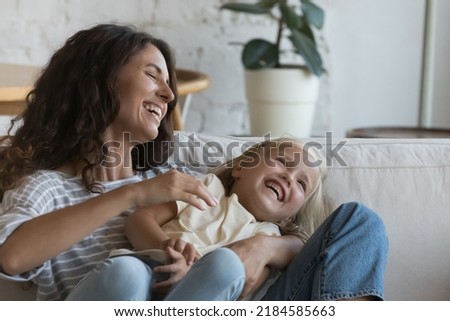 Excited happy mom tickling joyful little daughter, tickling kid, holding child in arms, playing active games with girl, laughing, smiling, enjoying family activity, leisure time, motherhood Royalty-Free Stock Photo #2184585663