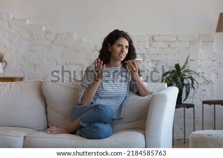 Happy engaged mobile phone user woman making telephone call on speaker, talking at mic, holding smartphone at mouth, speaking, recording audio message, dictating voice commands for Internet search