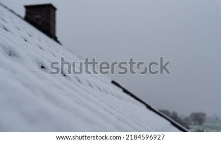 Snow on the roof with a chimney. Brick chimney in winter. House heating.