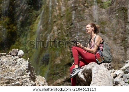 Serene Woman Listening on Earphones from Her Phone in Beautiful outdoors