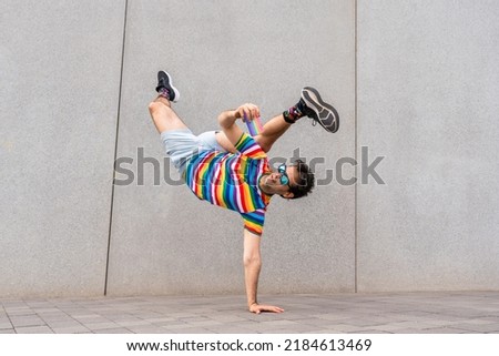 Happy and handsome adult businessman wearing elegant suit doing acrobatic trick moves in the city, alternative concept for business advertisement with energetic and creative people