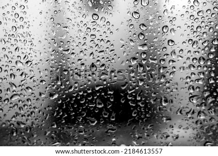 closeup of water drops on glass in black and white rain melancholy
