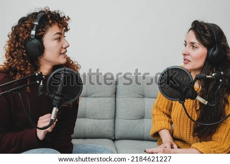 Female host recording radio podcast interview with guest at home office - Focus on latin woman face