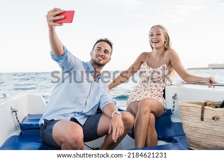 Happy young couple having fun on sailing boat during luxury summer vacations - Millenials taking selfie at the beach - Focus on girl face