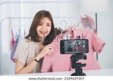 Happy young, lovely attractive Asian female blogger or vlogger looking at the camera and talking on recording video at home office. Social media influencer people or content maker concept.