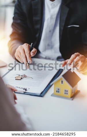 real estate agent Delivering sample homes to customers, mortgage loan contracts. Make a contract for hire purchase and sale of a house. and home insurance contracts, home mortgage loan concepts Royalty-Free Stock Photo #2184658295