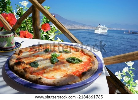                                Pizza Margarita served on flowery sea view terrace in Naples, Italy Royalty-Free Stock Photo #2184661765