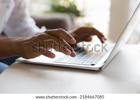 Young laptop user woman using computer, typing on keyboard. Female hands close up. Homeowner in casual, freelancer, writer working at table, sitting on home couch, chatting. Cropped shot Royalty-Free Stock Photo #2184667085