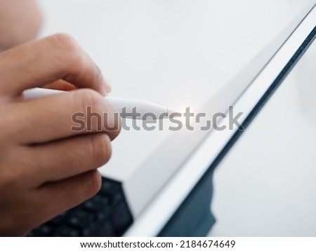 Close up white electronic pen or pencil in hand, write, draw or sign on digital tablet screen, computer isolated on white background. Business and technology concept. Working with tech device.