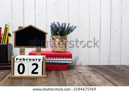 February 02 calendar date text on white wooden block with stationeries on wooden desk. Calendar date concept.