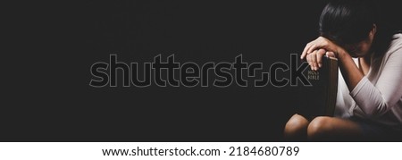 Asian christian woman person pray and worship for thank god in church with black background, The concept for faith, spirituality and religion, horizontal banner.