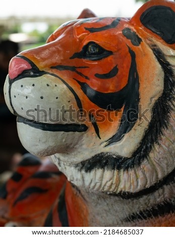 Head of tiger statue in the park on blur background.