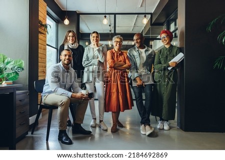Successful business professionals smiling cheerfully in a modern office. Group of multicultural businesspeople running a creative startup in an inclusive workplace. Royalty-Free Stock Photo #2184692869