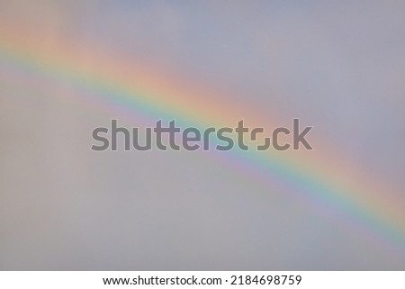 Rainbow. Ornamental clouds. Dramatic sky after the storm and rain. Soft sunlight. Panoramic image, texture, background, graphic resources, design, copy space. Meteorology, heaven, hope, peace concept