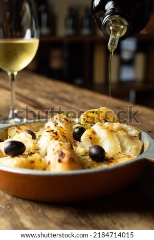 Traditional portuguese cousine. Cod fish with cooked potatoes and onions, covered with olive oil.