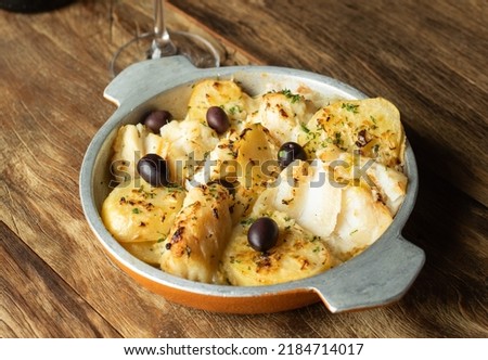 Traditional portuguese cousine. Cod fish with cooked potatoes and onions, covered with olive oil.