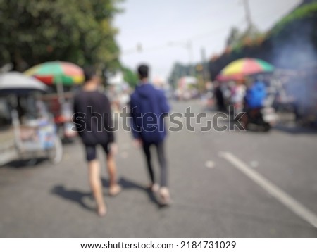 Defocused abstract background of two people looking for street food.