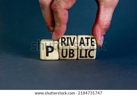Private or public symbol. Concept words Private or Public on wooden cubes. Businessman hand. Beautiful grey table grey background. Business and private or public concept. Copy space.