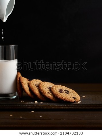 Milk and cookies. Dark, Moody. High resolution. Food Photography. Pouring Milk. 