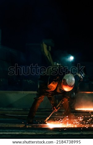An unrecognizable worker cutting steel 