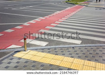 pedestrian crossing with teeth and red markings for the movement of bicycles on the roadway