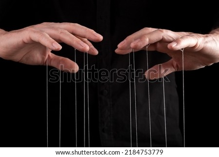 Hand manipulating and controlling smth with strings concept. High quality photo Royalty-Free Stock Photo #2184753779