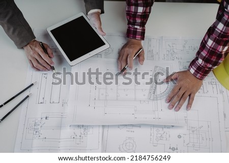 Close up of hands working and brainstorming on paperworks and floor plan drawings about design architectural and engineering for houses and buildings.