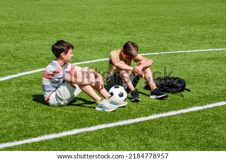 Teenage boy comforting consoling upset sad friend in school stadium. Education, bullying, conflict, social relations, problems at school, learning difficulties concept Royalty-Free Stock Photo #2184778957