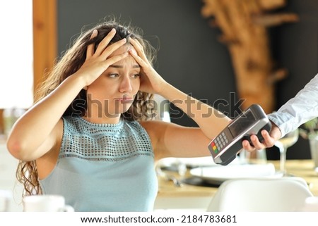 Worried woman complaining about expensive restaurant bill Royalty-Free Stock Photo #2184783681