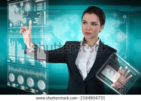 Young business lady works with virtual graphic interface in futuristic office