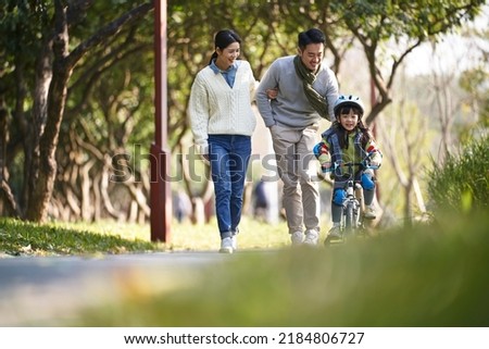 young asian family enjoying outdoor activity in city park Royalty-Free Stock Photo #2184806727