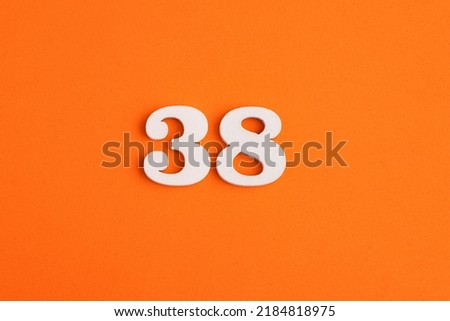 White wooden number 38 on eva rubber orange background