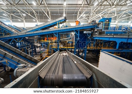 Conveyor carries trash pieces in recycling plant workshop Royalty-Free Stock Photo #2184855927