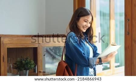 Education and literacy concept, College student girl standing in library to taking note on notebook.