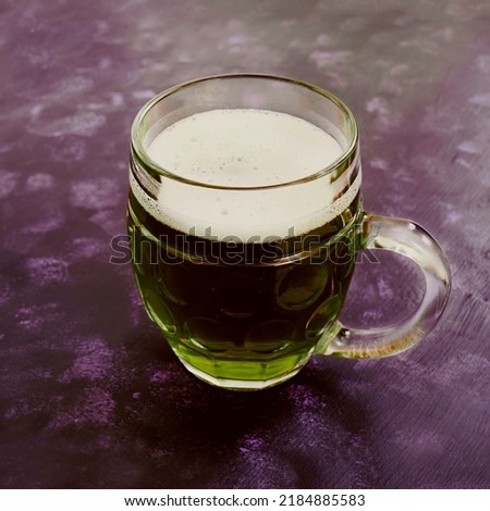 Mug of green beer on dark background