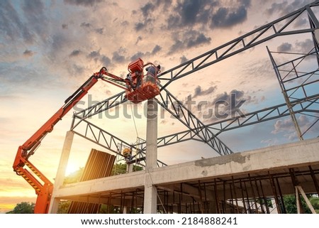 Construction workers working on Construction machine. Aerial platform for workers who work at height on buildings.  Royalty-Free Stock Photo #2184888241