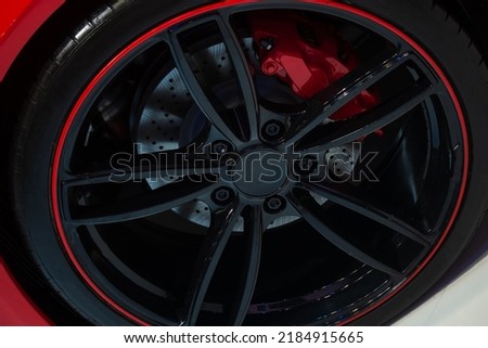 Black mags with red rims of a luxury sports car.