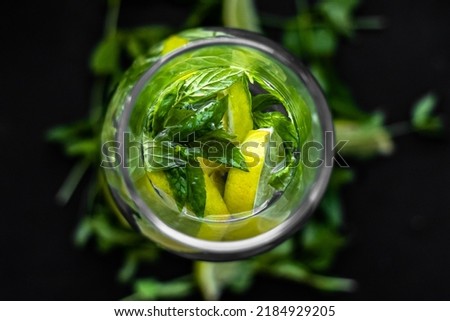 Lime and mint. Summer freshness. Natural background. Ingredients of lemonade. Yellow and green colors in still life. A sprig of mint. Sliced lime.