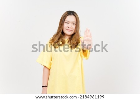 Stop hand rejection gesture of Beautiful Asian Woman wearing yellow T-Shirt Isolated On White Background