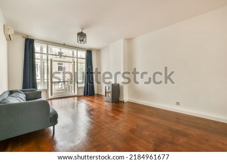 Shabby wooden table with chairs and vase located near comfortable couch against light walls with decorations and fireplace in modern apartment