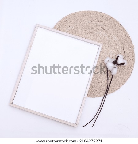 Photo frame mockup and cotton plant decoration on white background. Flat lay, top view, copy space.