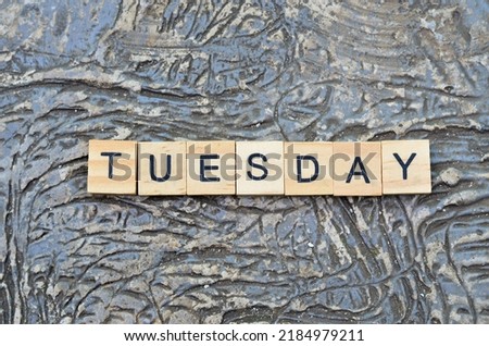 tuesday text on wooden square, suitable for business quotes