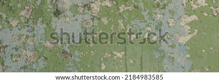 Peeling paint on the wall. Panorama of a concrete wall with old cracked flaking paint. Weathered rough painted surface with patterns of cracks and peeling. Wide panoramic texture for grunge background Royalty-Free Stock Photo #2184983585