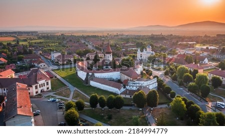 Prejmer, Romania. Sunrise golden hour aerial drone view of Prejmer fortified Church. UNESCO world heritage site in Transylvania. Royalty-Free Stock Photo #2184994779